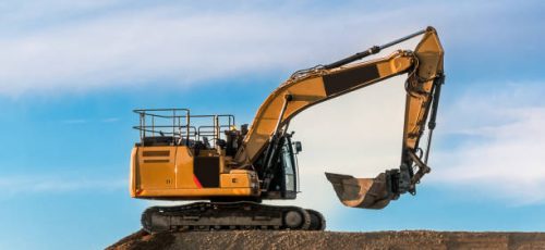 Large yellow heavy machinery excavator digger on a road construction site